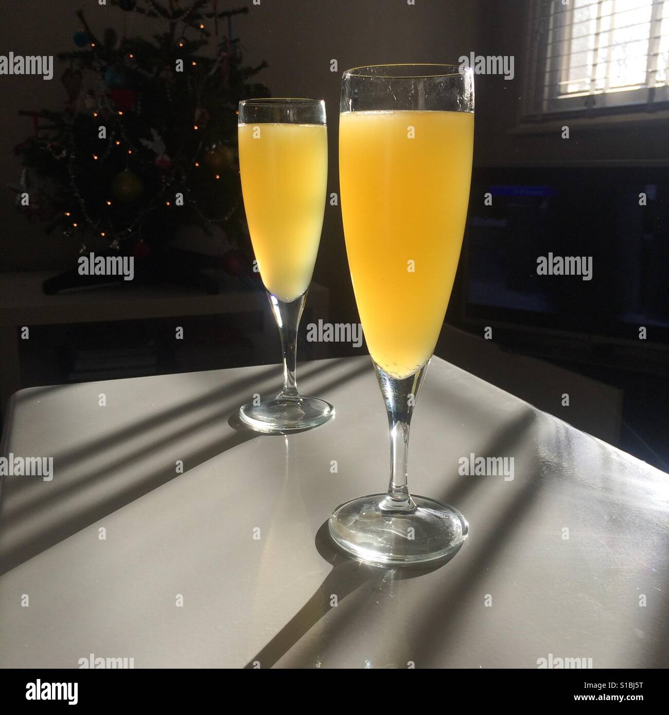 Two glasses of Buck's Fizz on a table Stock Photo