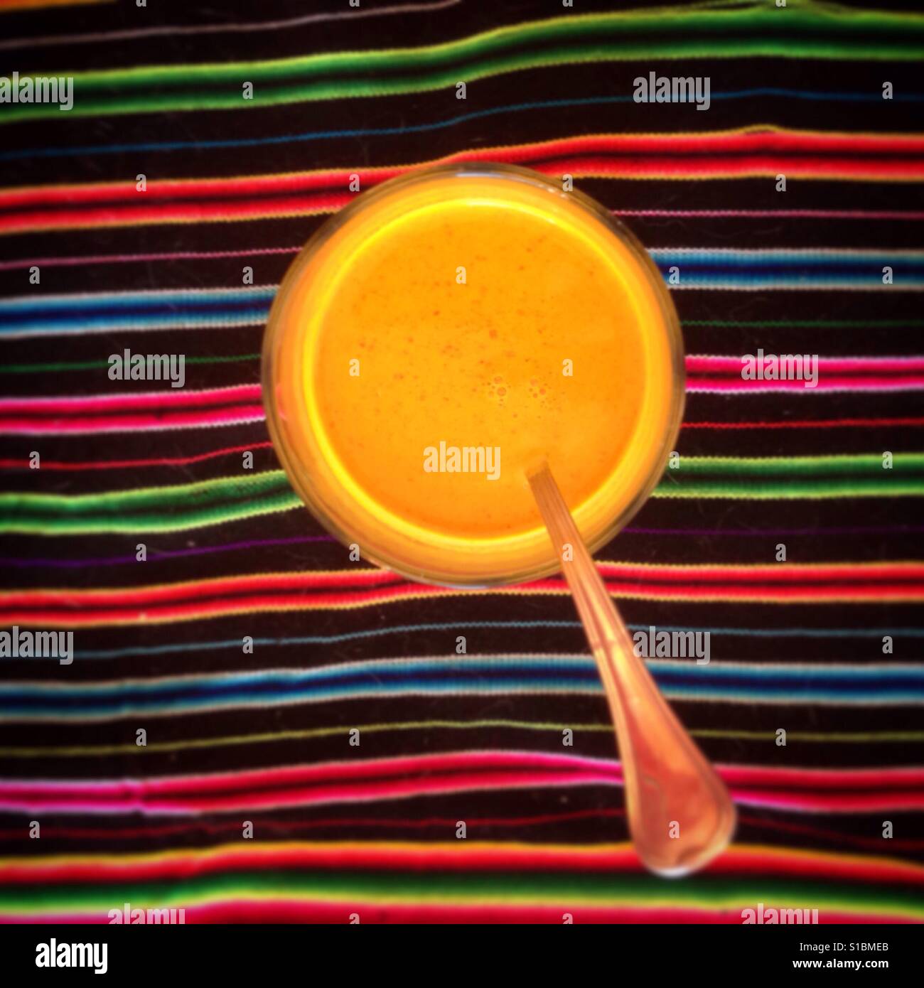 Turmeric sauce with honey on a Peruvian tablecloth with a spoon - Smartphone Captured Stock Image