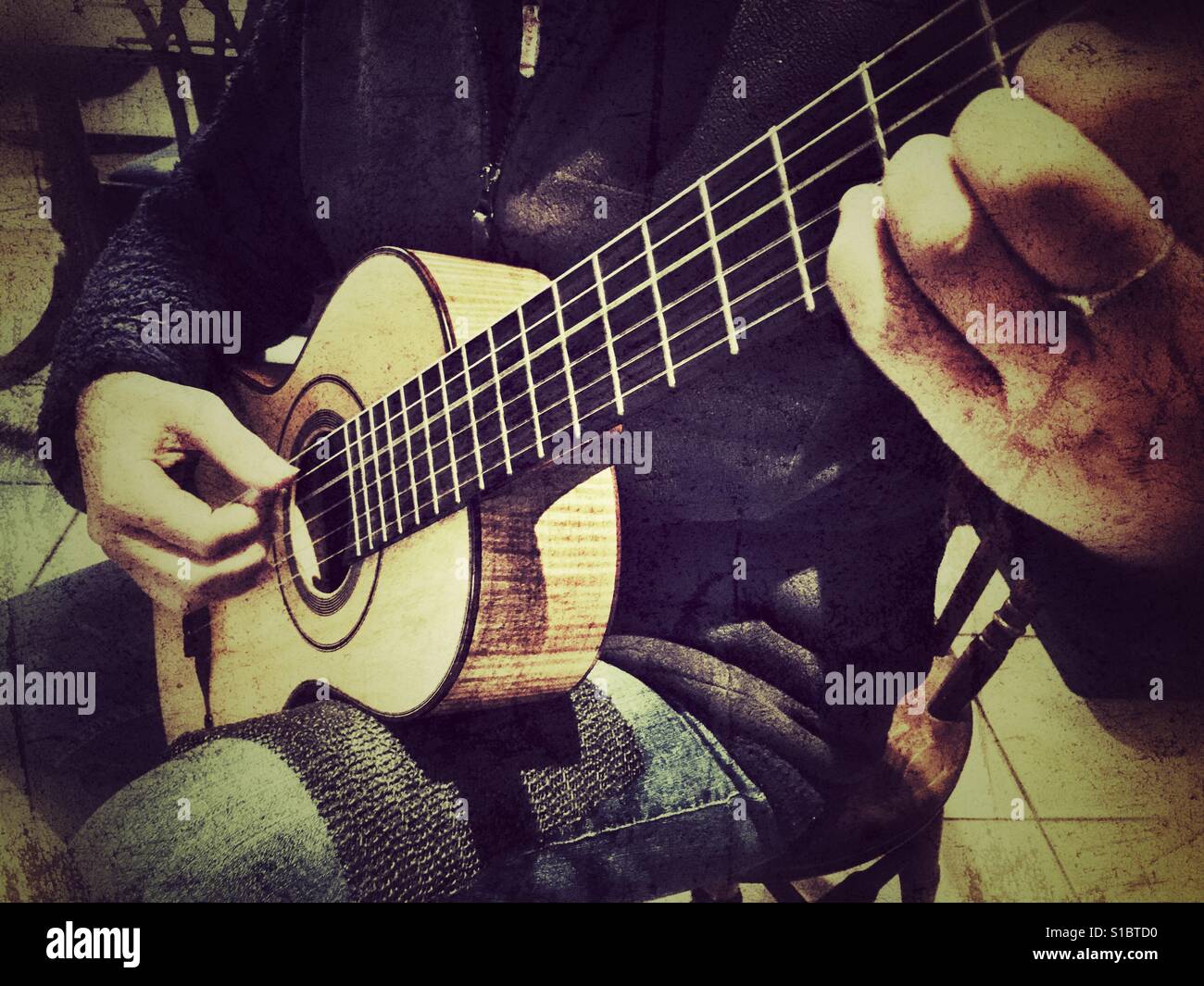 High angle view of a woman playing a replica of a 19th century Panormo Fecit guitar - Smartphone Captured Stock Image