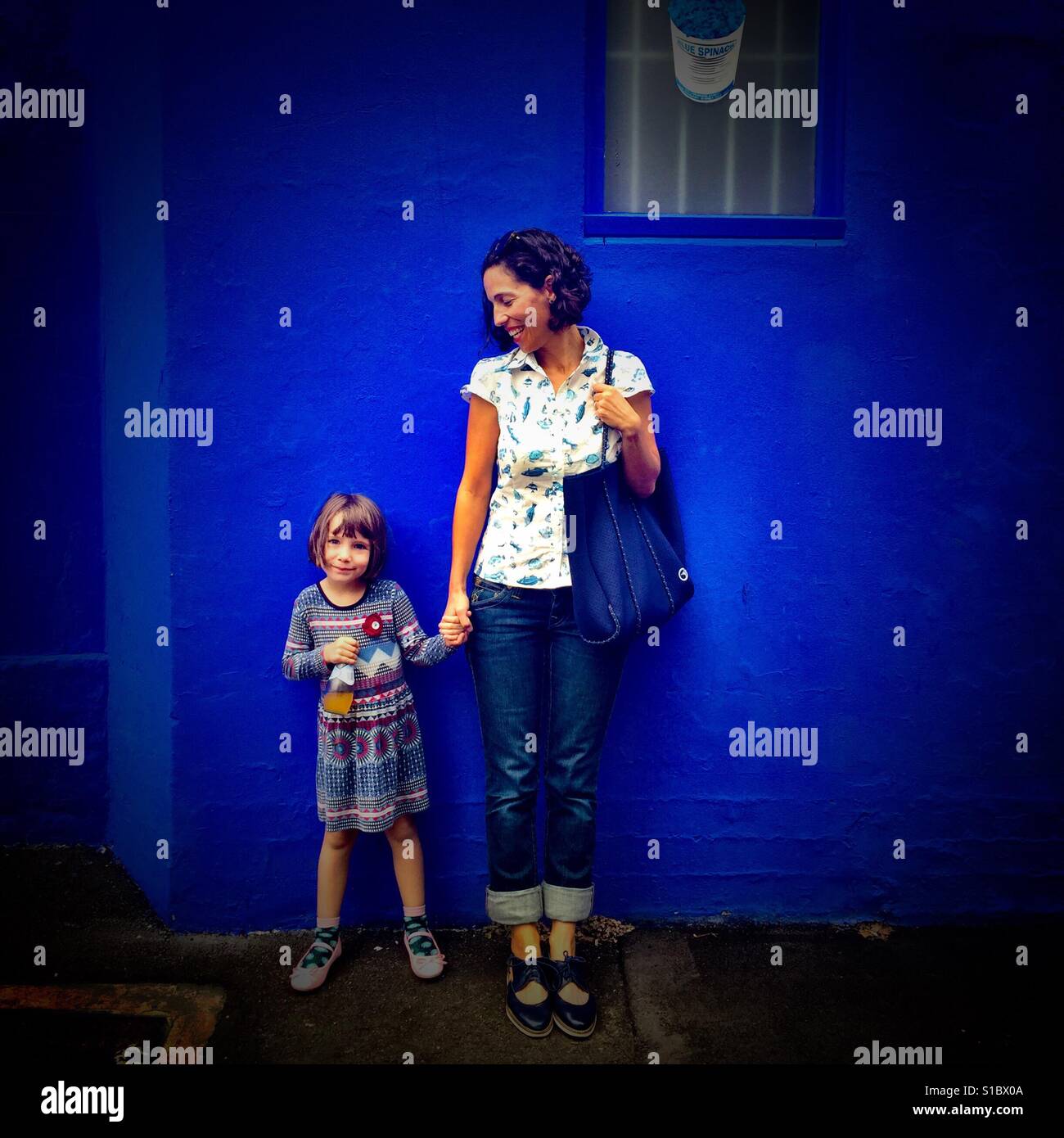 Mother and Daughter. Mother looking at daughter, daughter looking at camera. - Smartphone Captured Stock Image