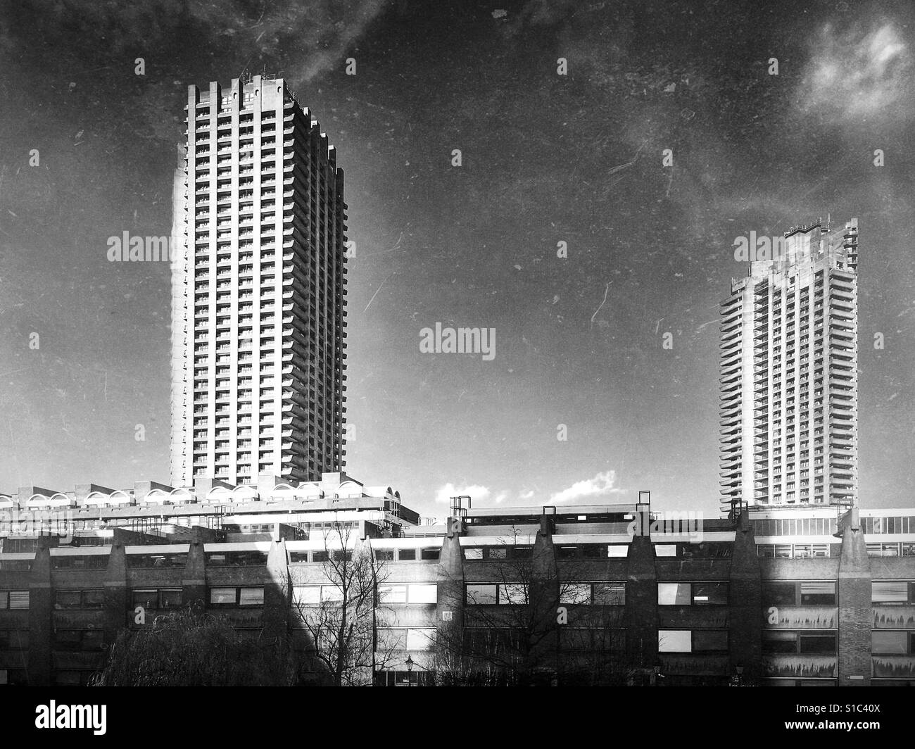 Black and white photo of the tower blocks of the Barbican Estate, a prominent example of British brutalist architecture, in London, England, UK. Stock Photo