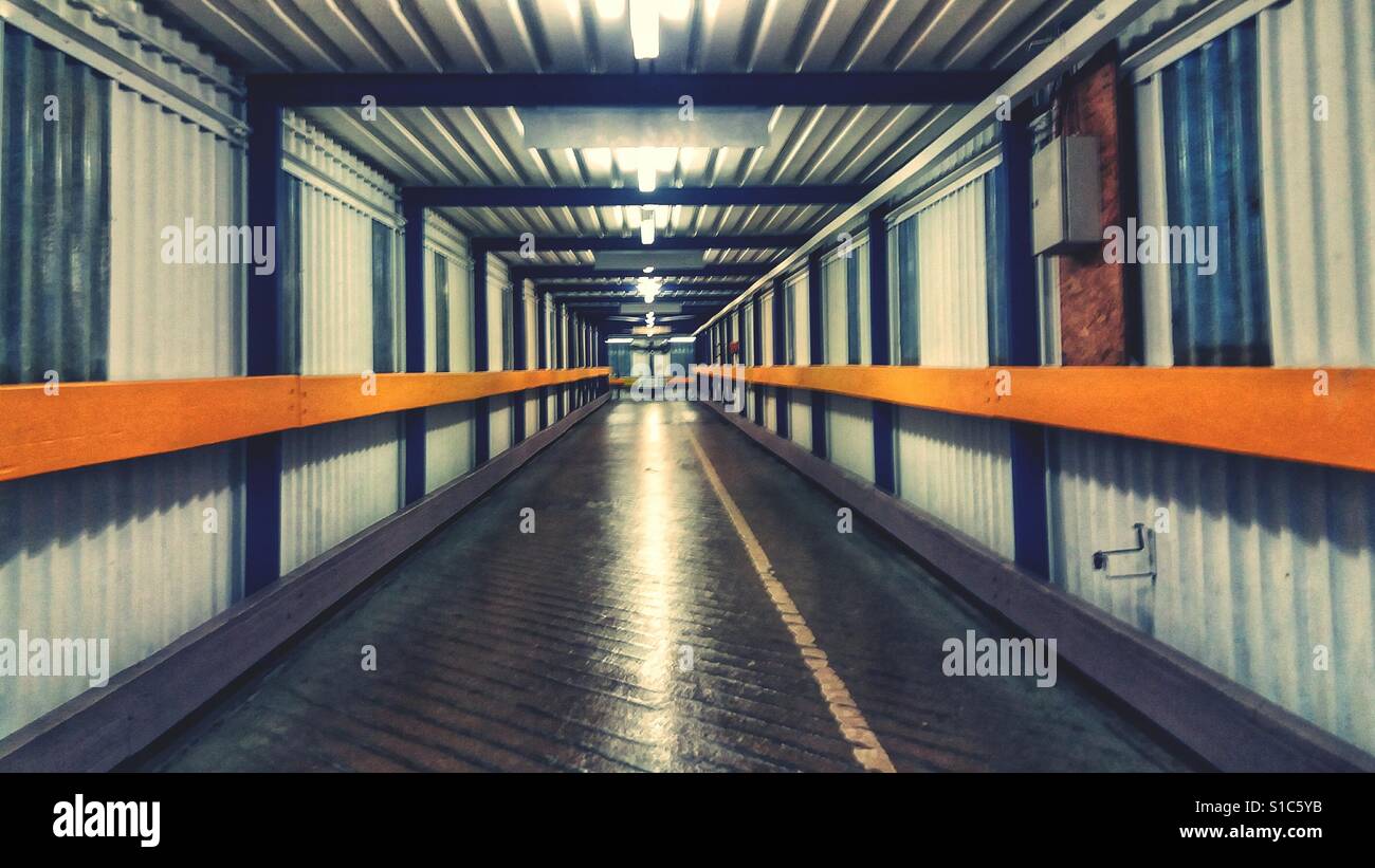 A deserted underground subway tunnel with straight lines and a diminishing perspective. - Smartphone Captured Stock Image