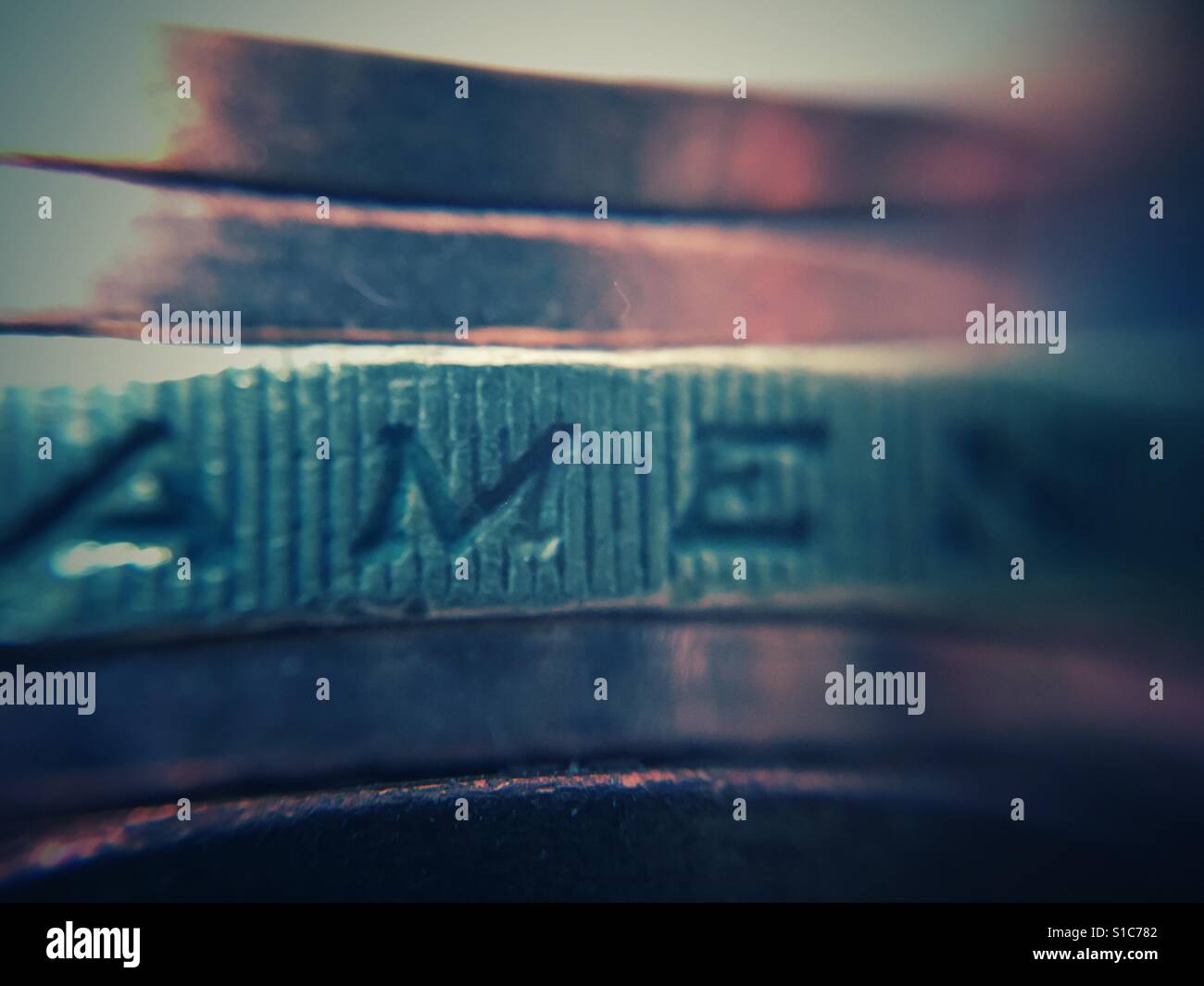 Macro of English coins, focus on the word amen (out of tutamen) on the milled edge of a £1 coin - Smartphone Captured Stock Image