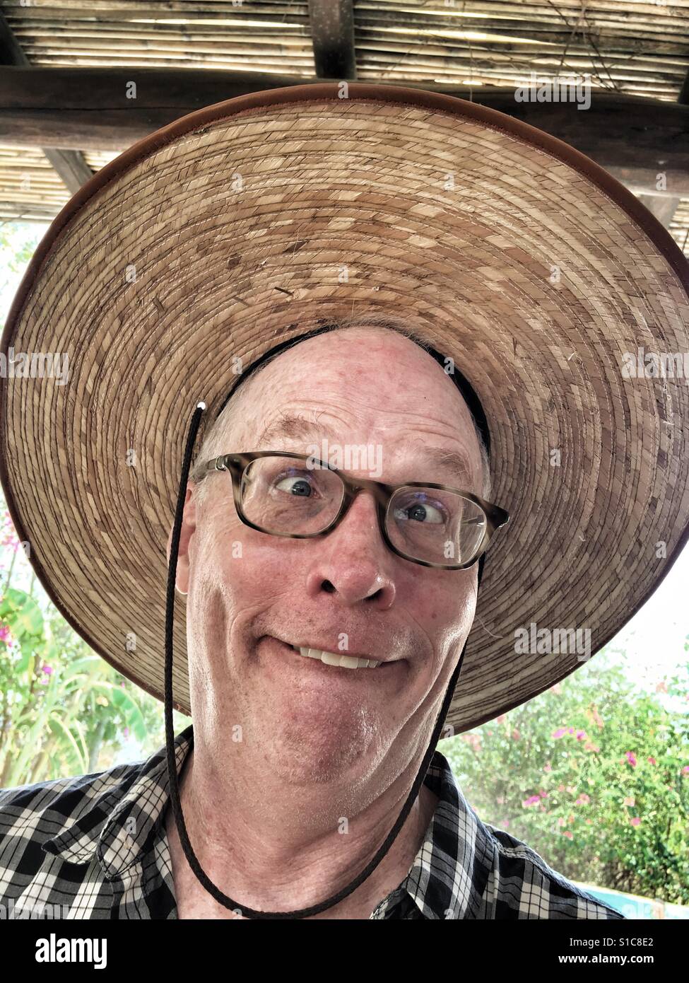Man making funny face with giant hat Stock Photo