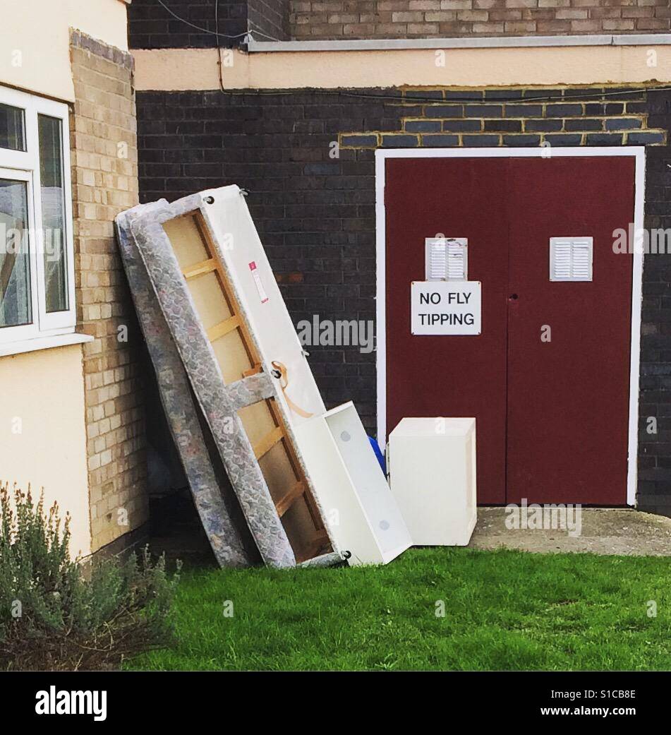 Rubbish dumped in a residential area despite a warning notice Stock Photo