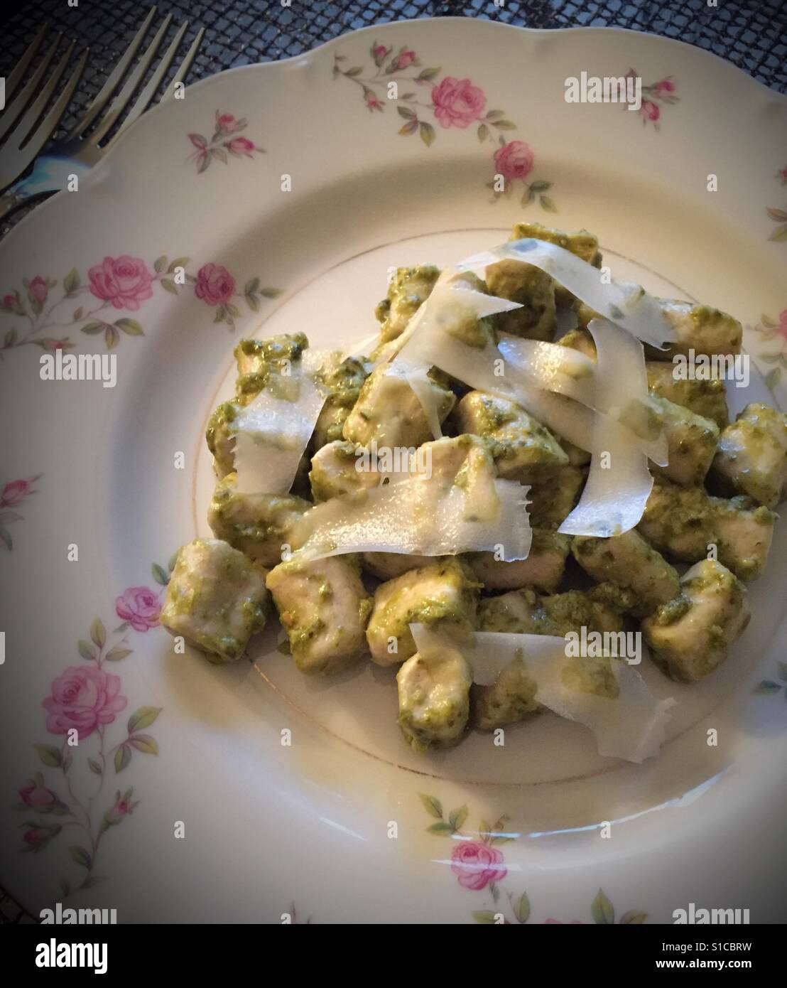 Fresh gnocchi with pesto and slices of Parmesan on a China plate - Smartphone Captured Stock Image