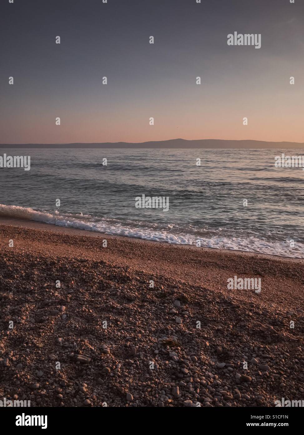 Beautiful sunset on pebble beach Stock Photo
