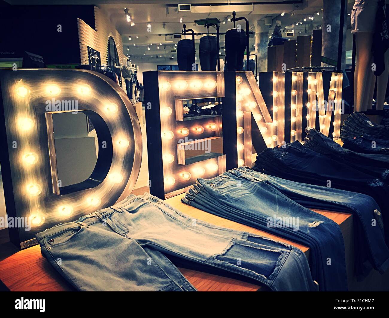 Huge brightly lit denim sign over Jeans display, NYC, USA - Smartphone Captured Stock Image