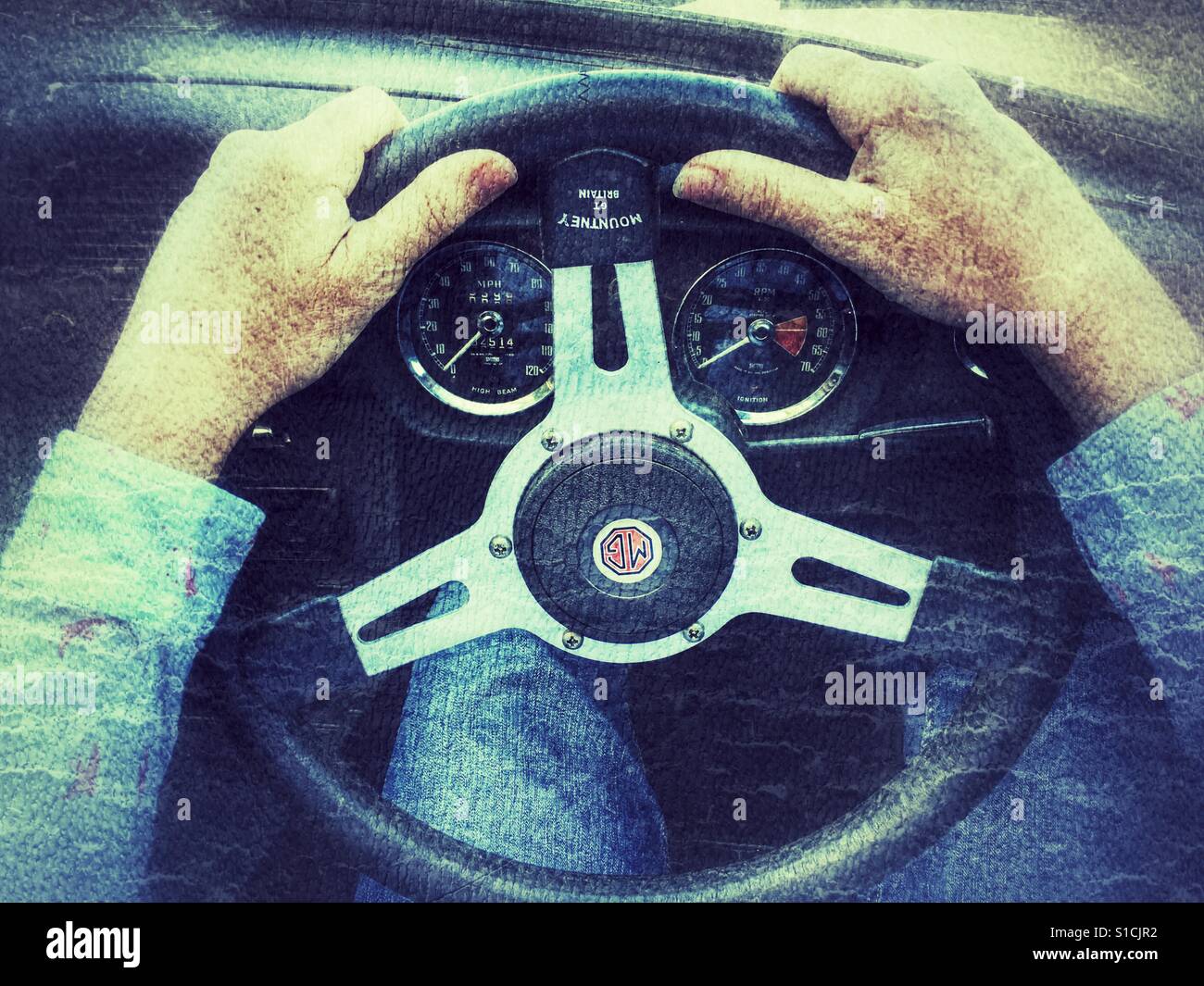 POV Woman's hands on the steering wheel of a 1973 MGB Roadster - Smartphone Captured Stock Image