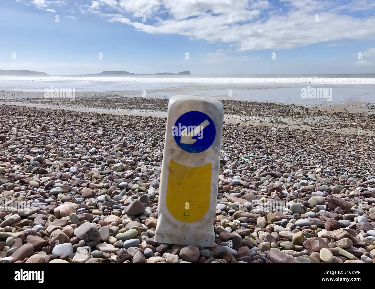 Traffic island direction sign washed up on Llangennith beach on the Gower Peninsula near Swansea after heavy storms. - Smartphone Captured Stock Image