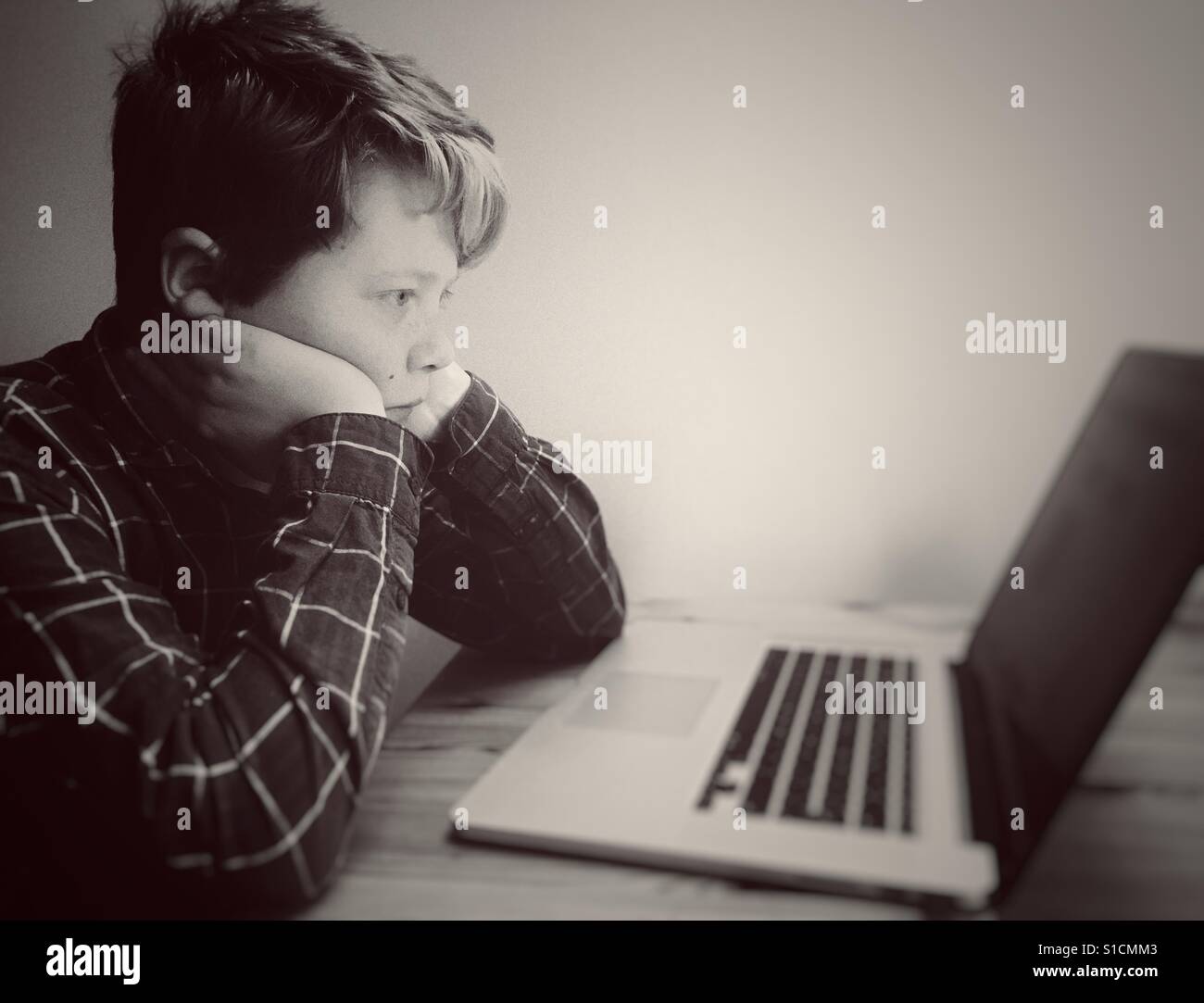 11-year old boy using laptop computer - Smartphone Captured Stock Image