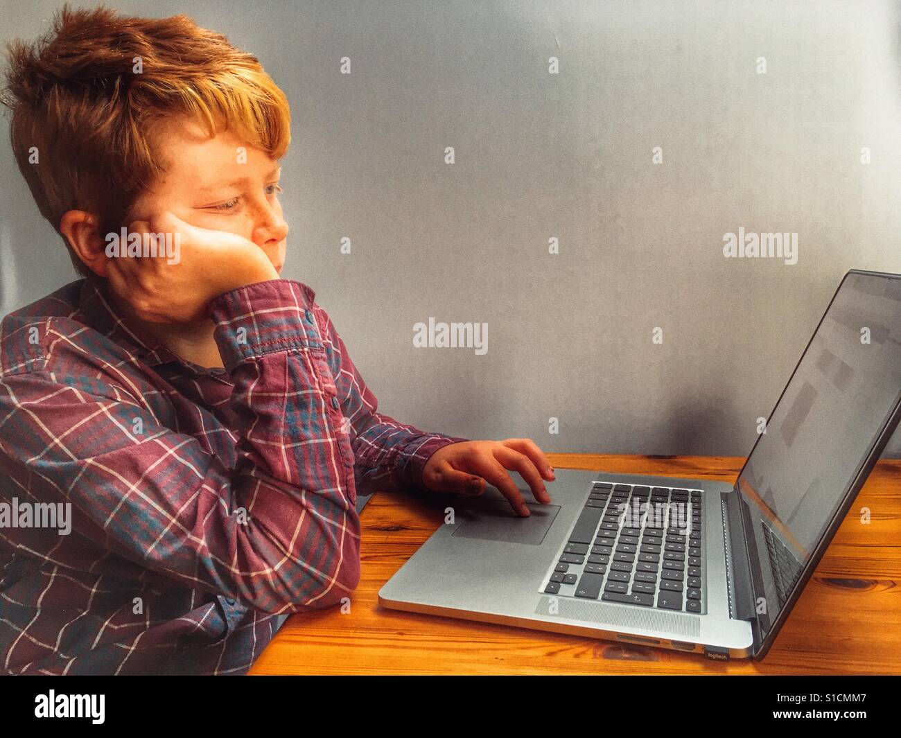 11-year old boy using laptop computer - Smartphone Captured Stock Image