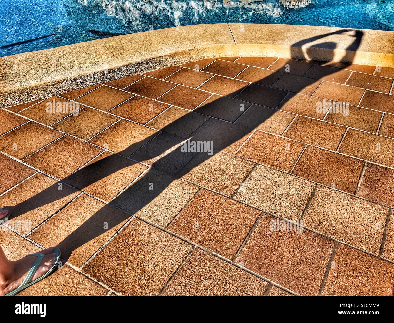 Human shadow, arms above head, ready to dive into swimming pool Stock Photo