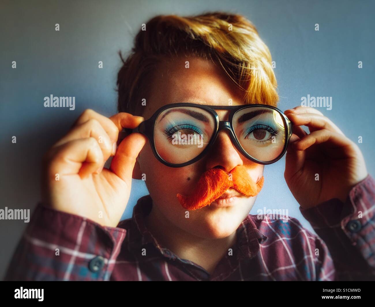 Ginger haired boy with ginger comedy moustache and comedy glasses - Smartphone Captured Stock Image