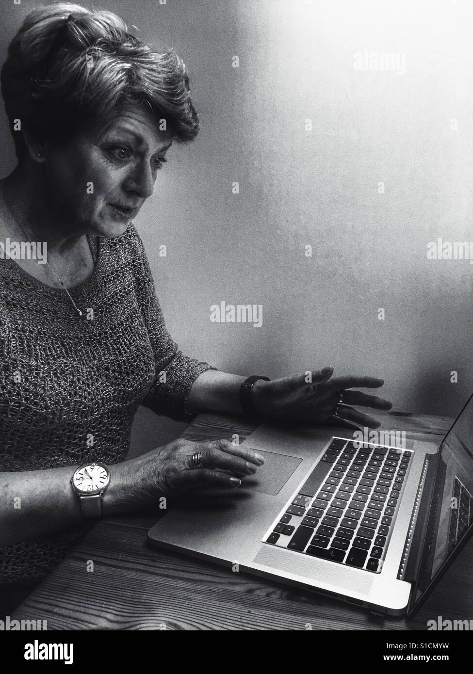 Woman using a laptop computer at night - Smartphone Captured Stock Image