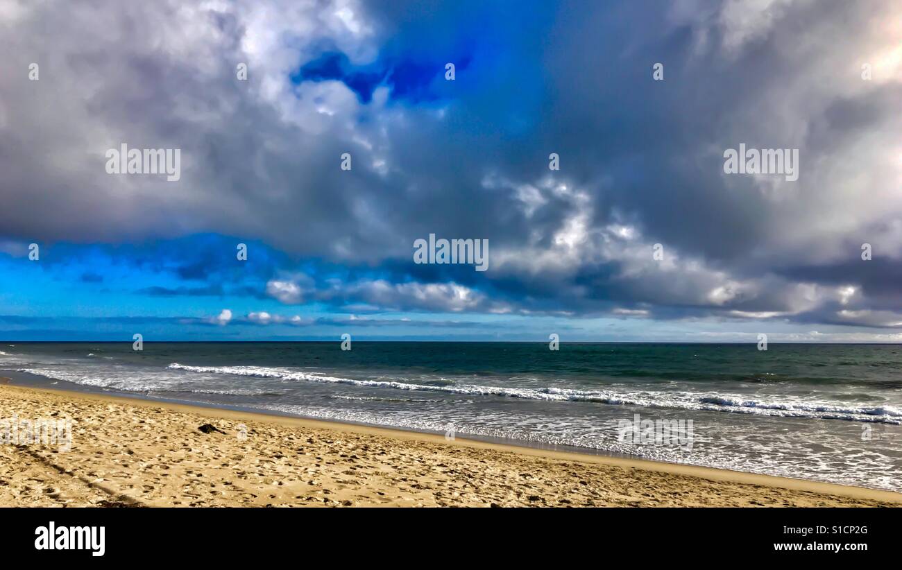 Serene sandy beach, ocean, blue sky and white clouds Stock Photo - Alamy