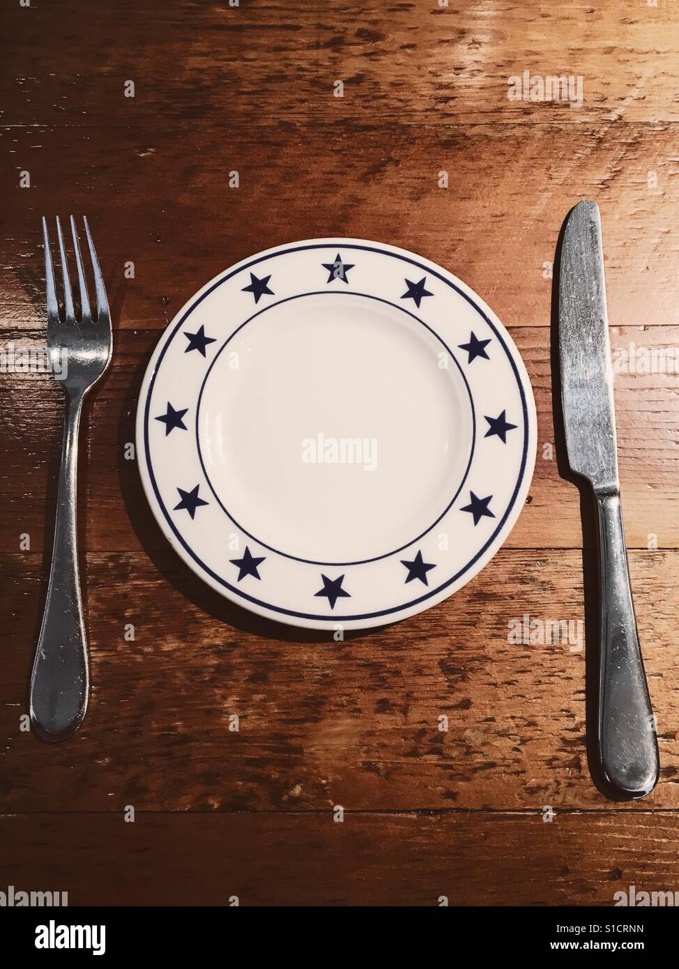 Empty plate with fork and knife - Smartphone Captured Stock Image