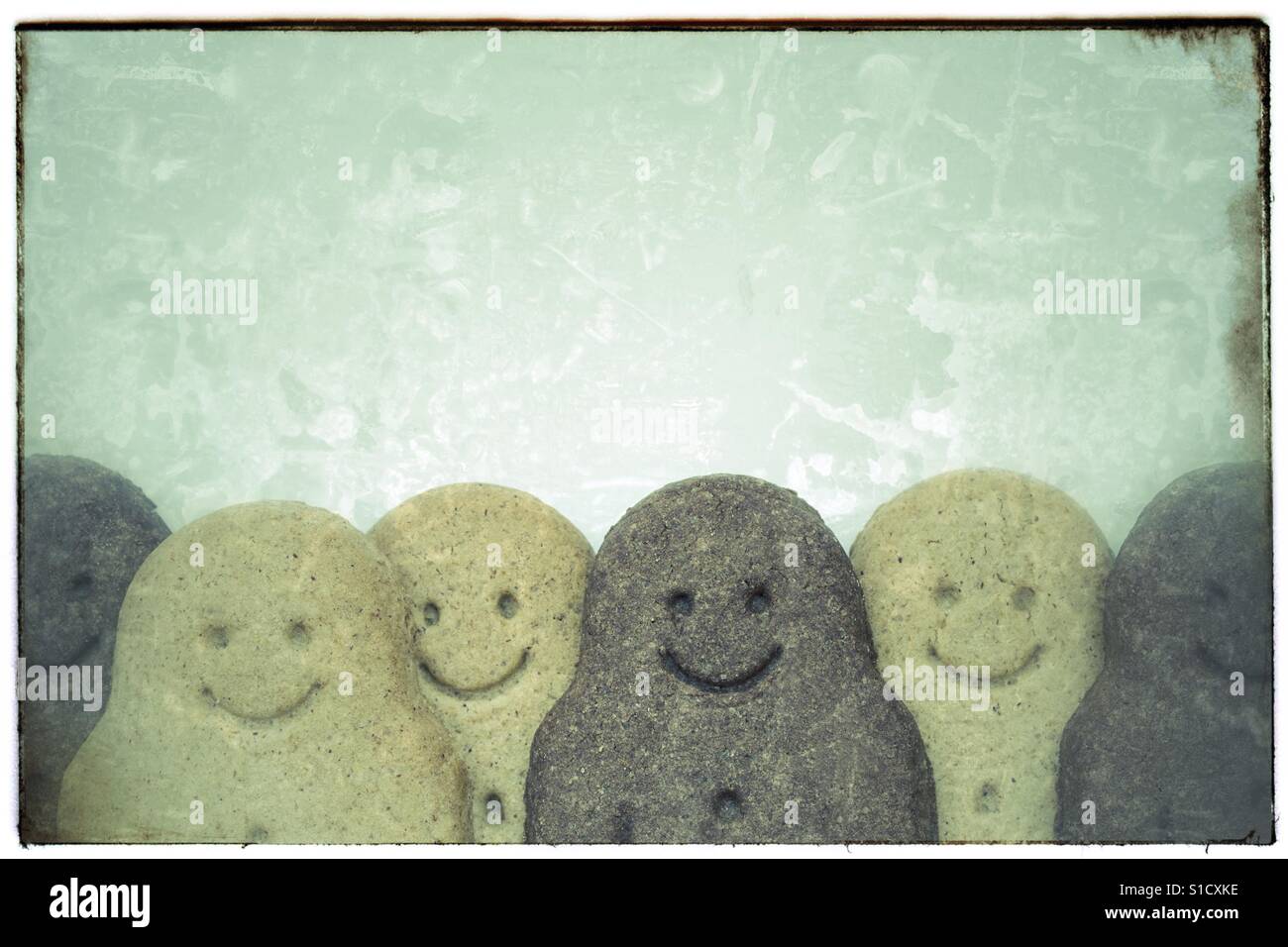 A row of black and white gingerbread men in a vintage photograph frame. - Smartphone Captured Stock Image