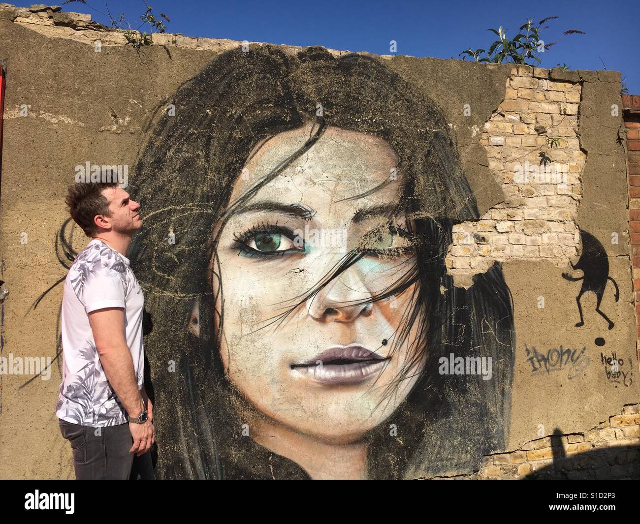 Man looking bored next to graffiti - Smartphone Captured Stock Image