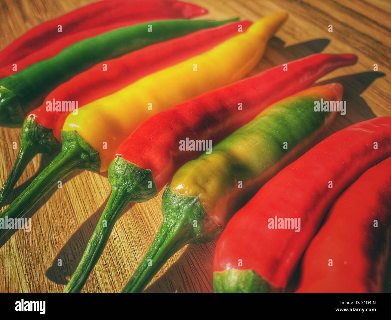 Colourful red hot chilli peppers on a bamboo chopping board - Smartphone Captured Stock Image