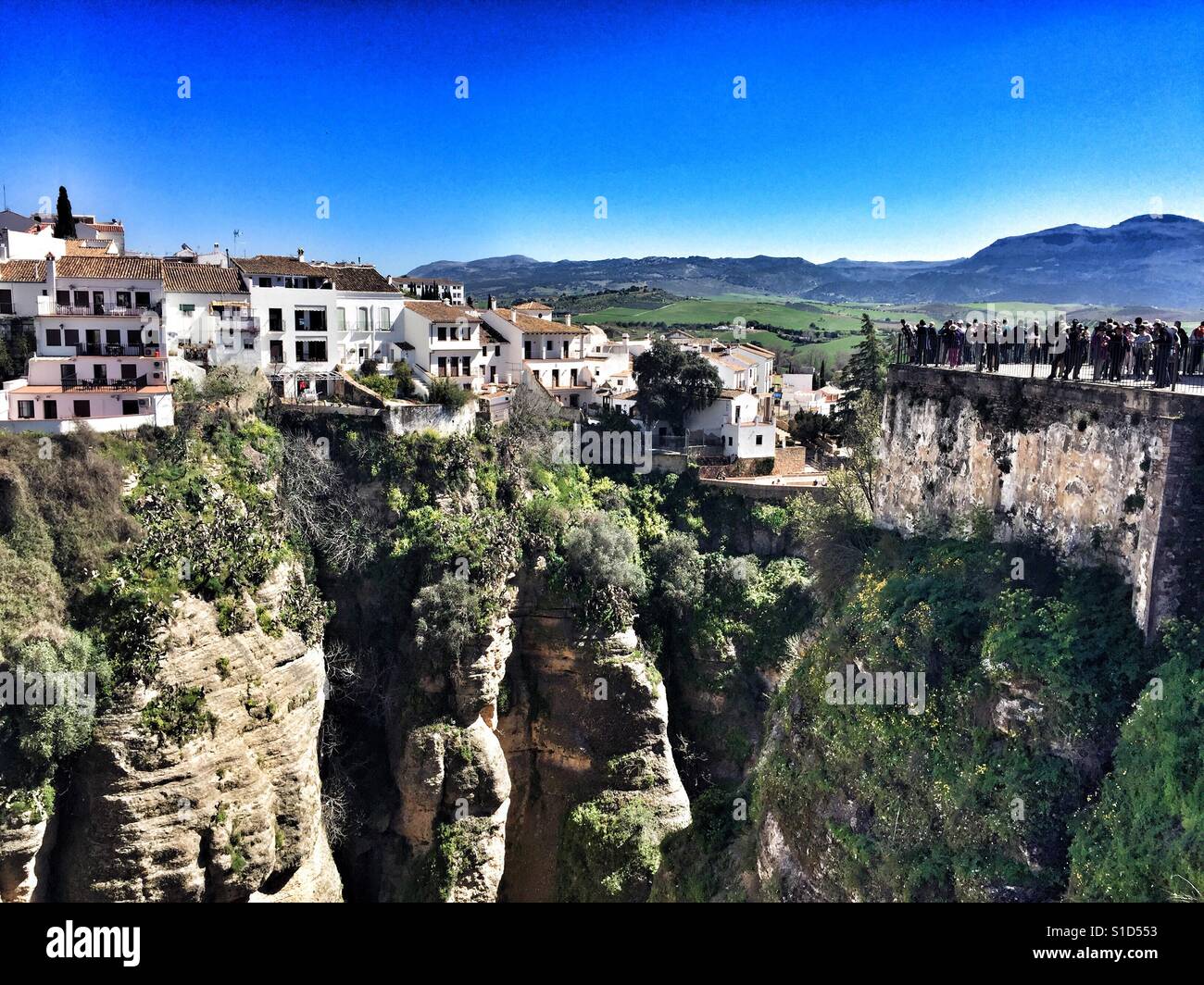 Group of tourists looking out from a vantage point on the edge of Ronda, Andalucia, Southern Spain - Smartphone Captured Stock Image
