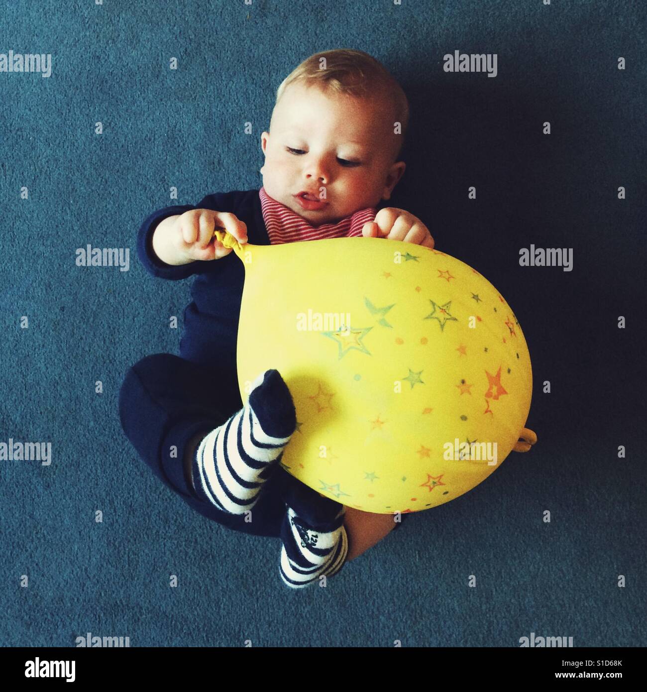 Baby boy playing with a yellow balloon Stock Photo