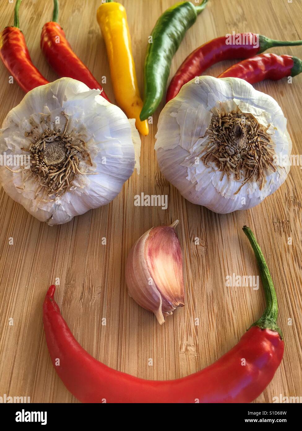 Food art. Smiley face made up from fresh garlics and Chillies - Smartphone Captured Stock Image