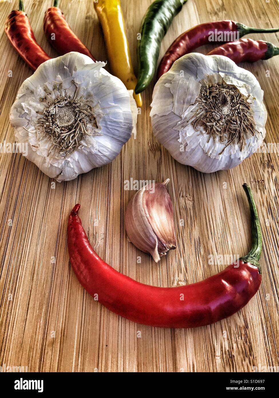 Food art. Smiley face made up from fresh garlics and Chillies - Smartphone Captured Stock Image