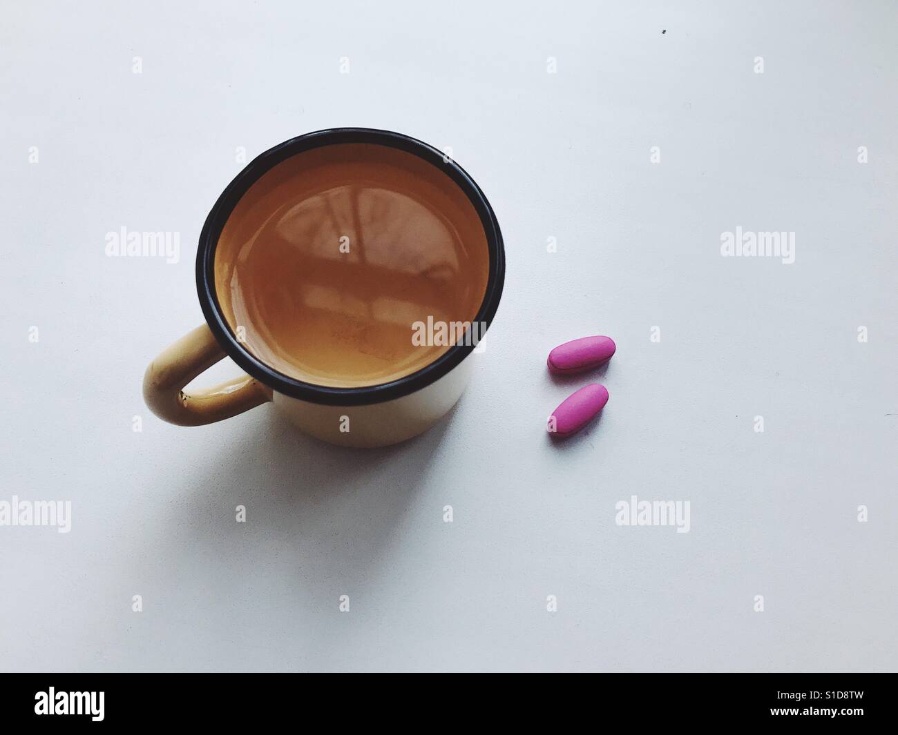 A cup of water with medicine pills, ready to be taken in the morning. Stock Photo