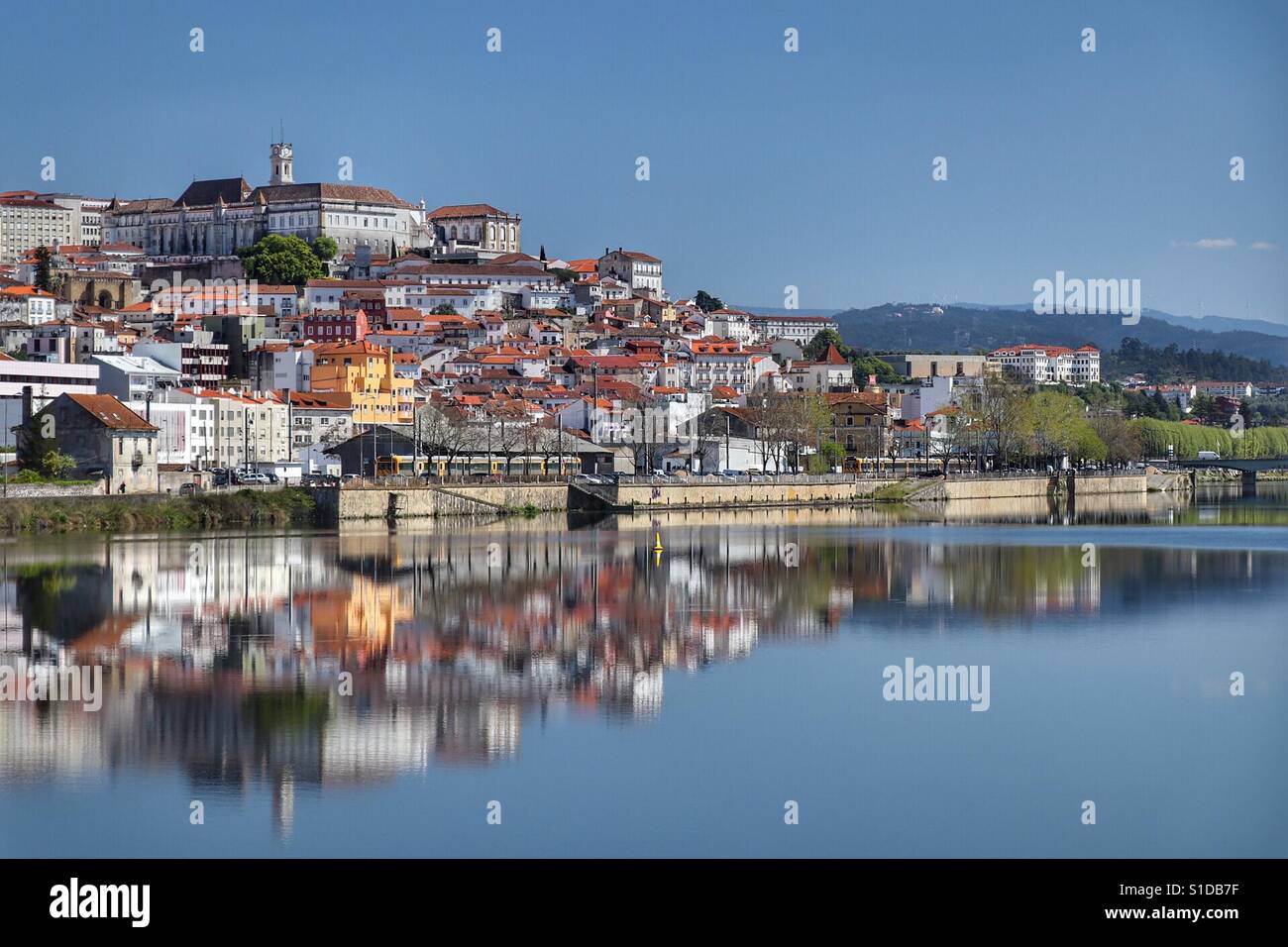City reflection on river. Coimbra, known as the student city, home to the oldest university in Portugal, classified as World Heritage. Located on the bank of the river Mondego Stock Photo