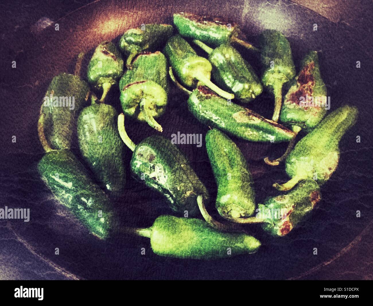 Pimientos de Padron, Capsicum annum, from Galicia cooking In a frying pan. - Smartphone Captured Stock Image