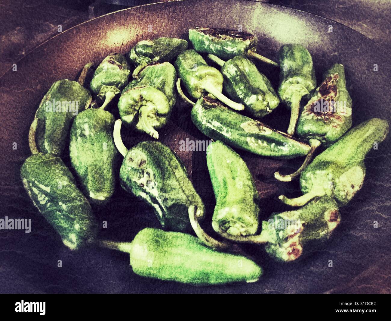 Pimientos de Padron, Capsicum annum, from Galicia cooking In a frying pan. - Smartphone Captured Stock Image