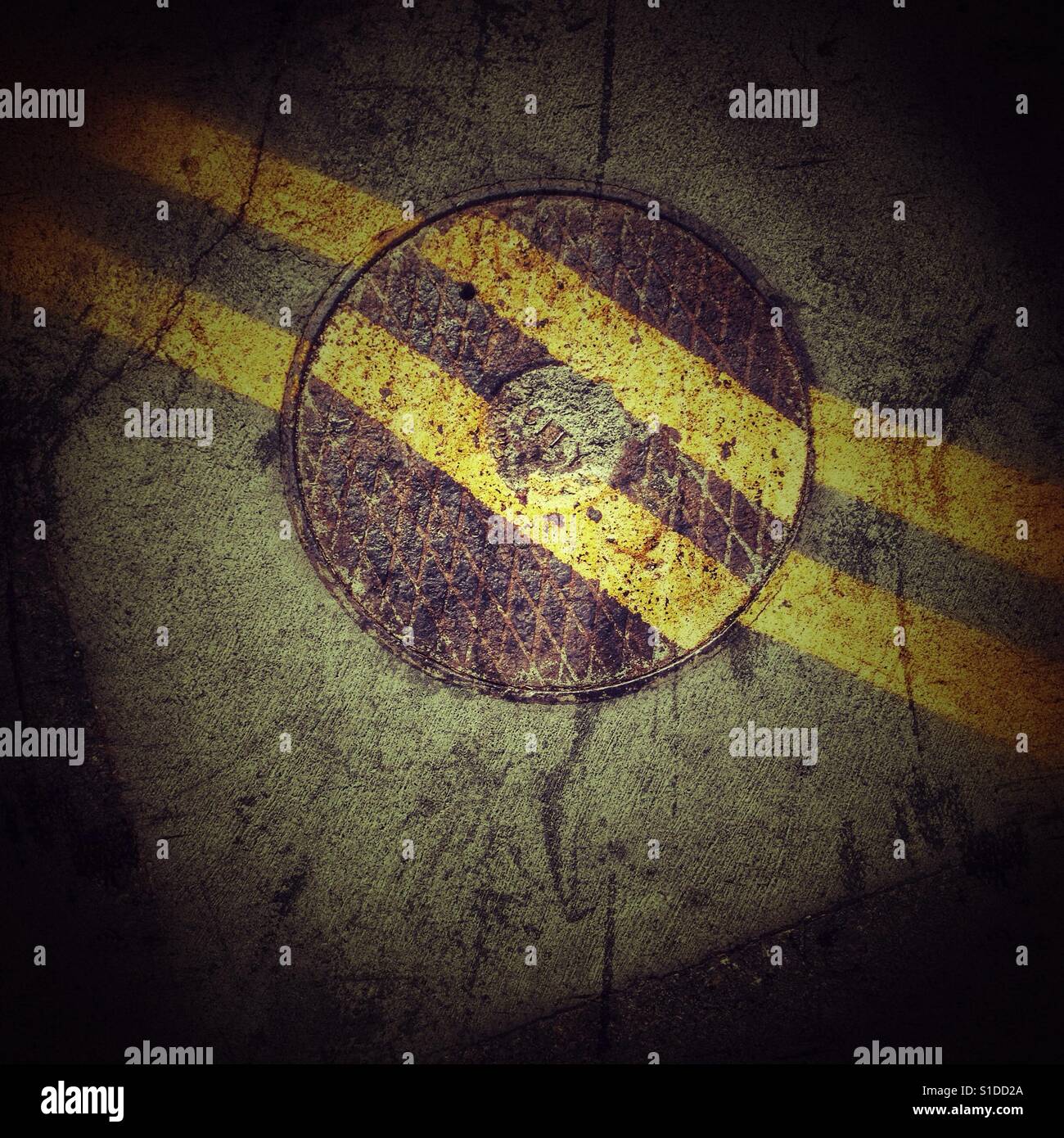 Manhole cover double yellow lines Stock Photo