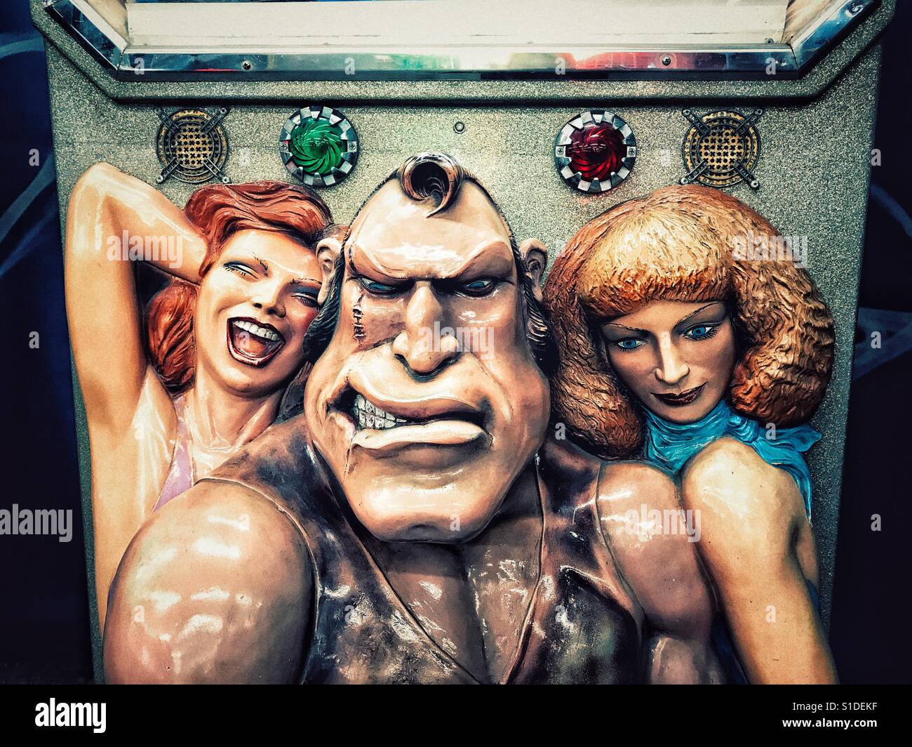 Macho-looking man with two women on either side fun fair arm wrestling art Stock Photo