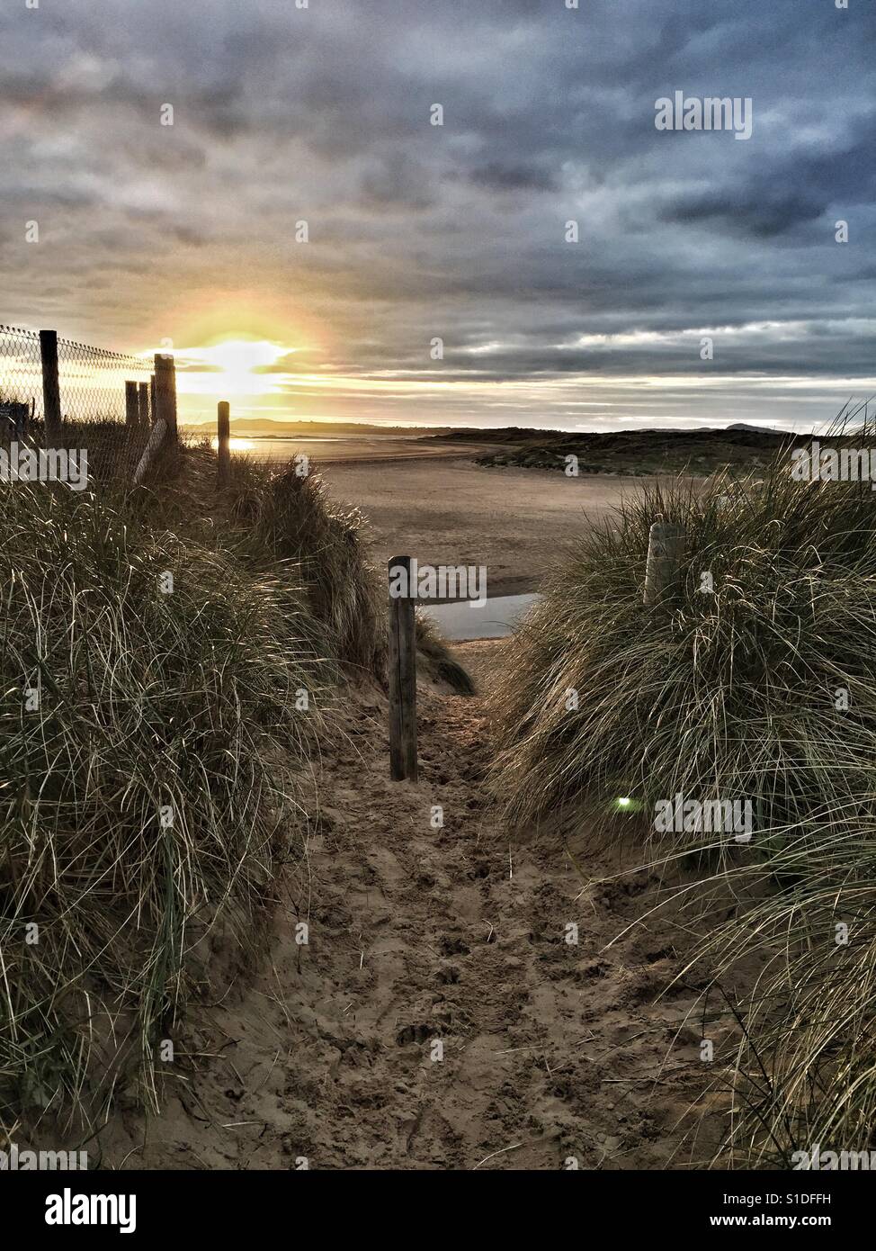 Sun setting through the sand dunes on Rhosneigr beach - Smartphone Captured Stock Image