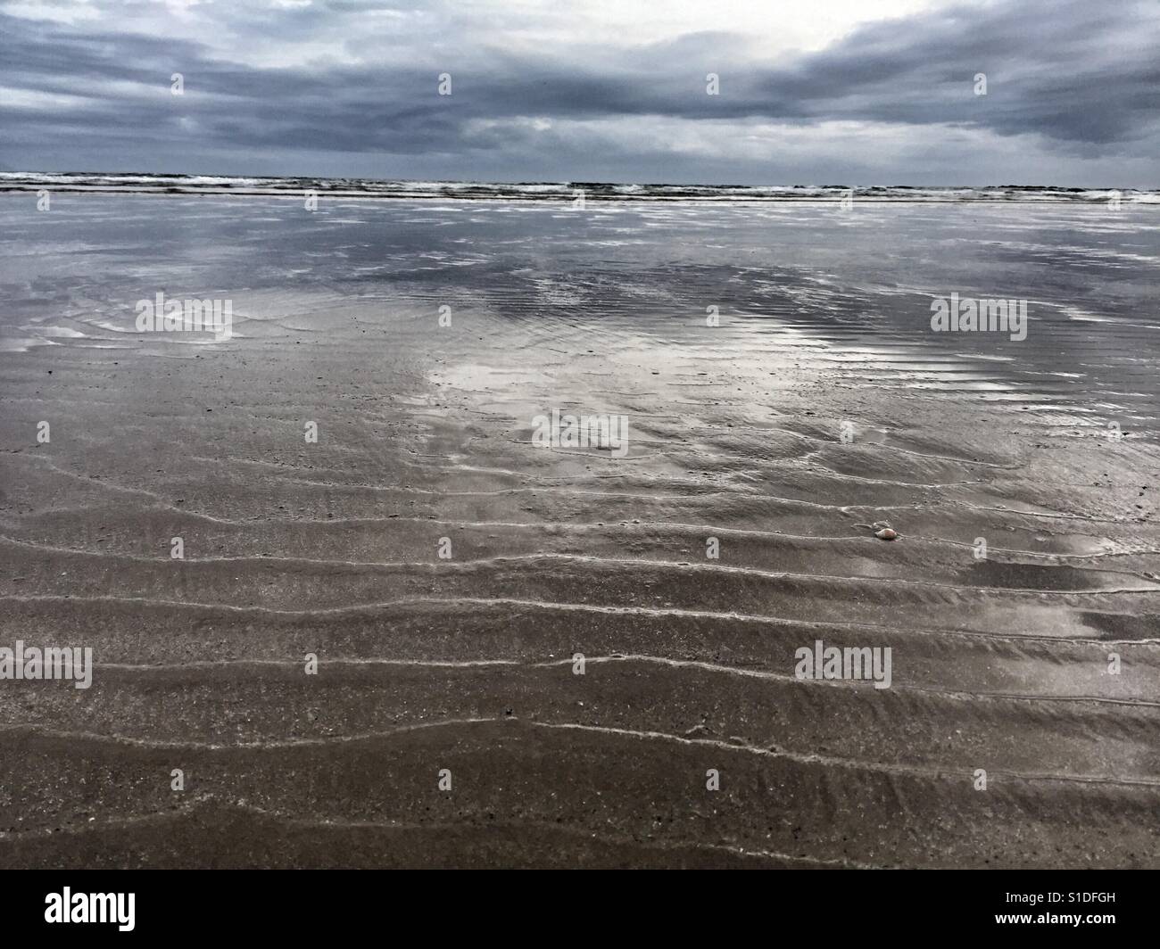 Waves breaking on Cymyran beach at dusk and low tide - Smartphone Captured Stock Image