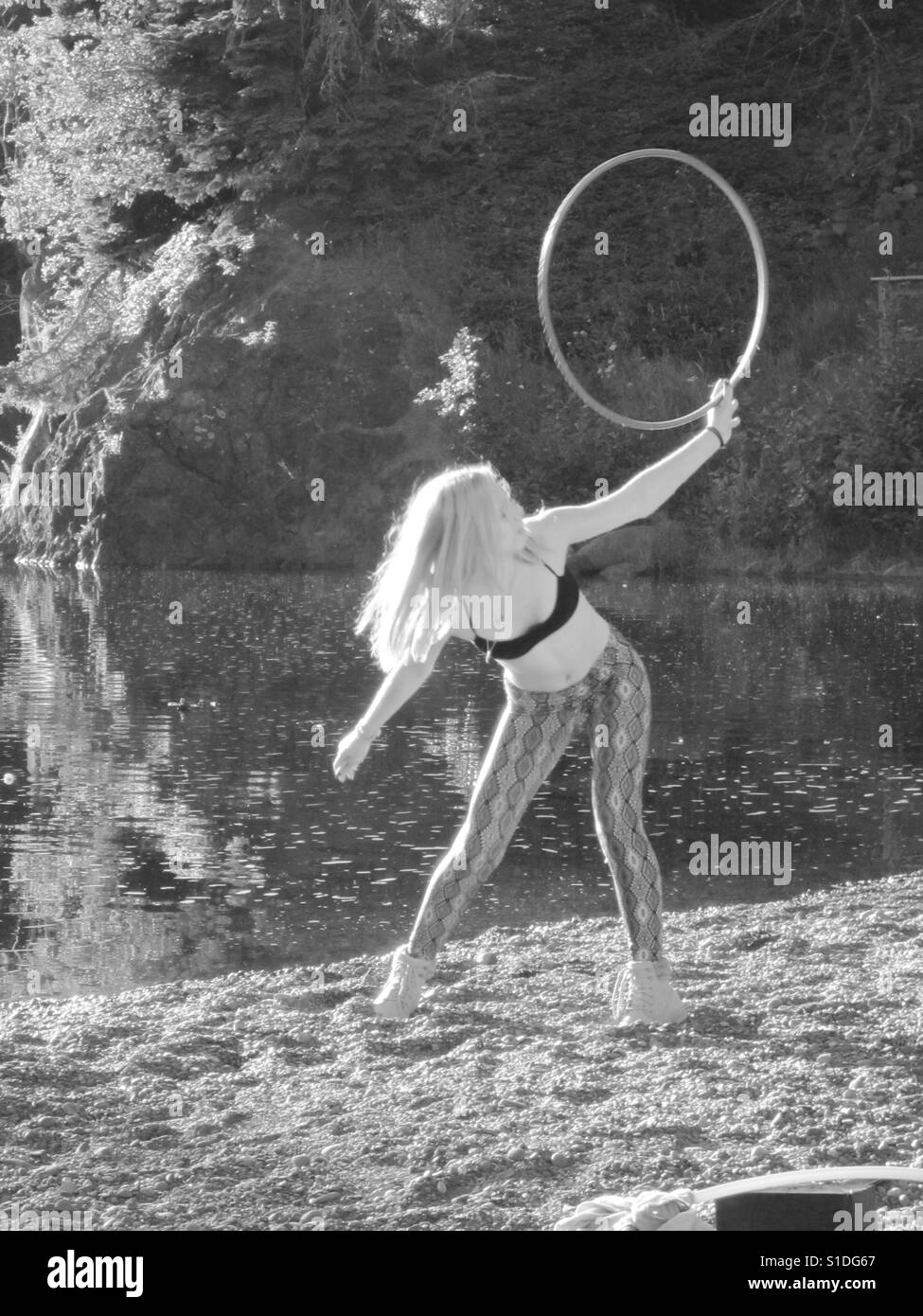 Young lady hooping by the lake. Stock Photo