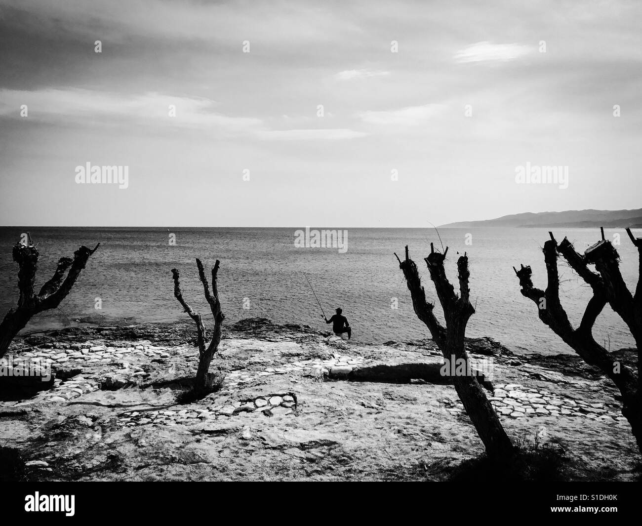 Man fishing along coast - Smartphone Captured Stock Image