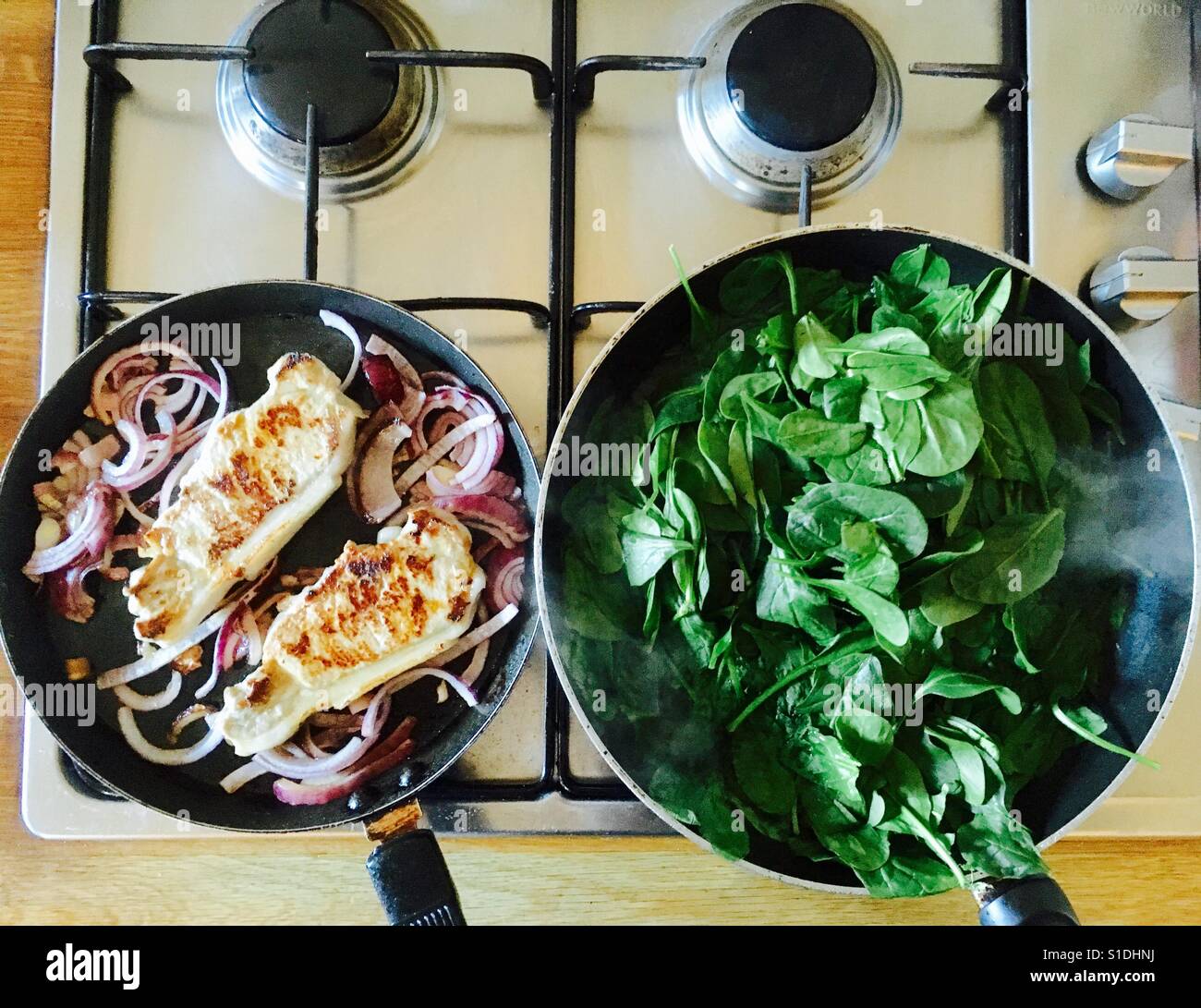 Pork loin steaks and garden Spinach cooking on hob - Smartphone Captured Stock Image