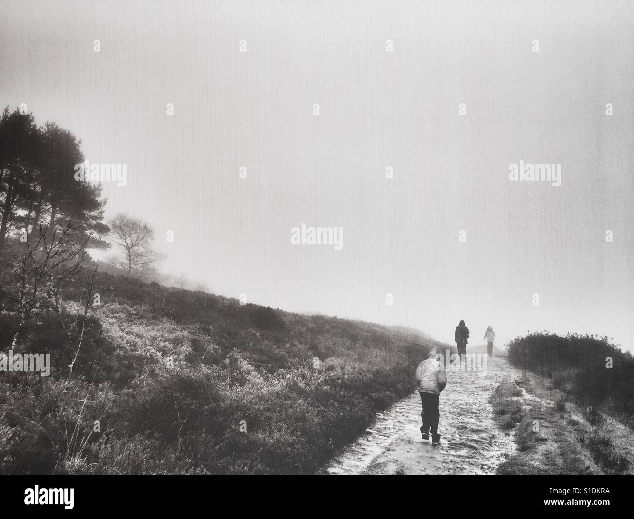 Family walking on the moors in the mist and rain Stock Photo