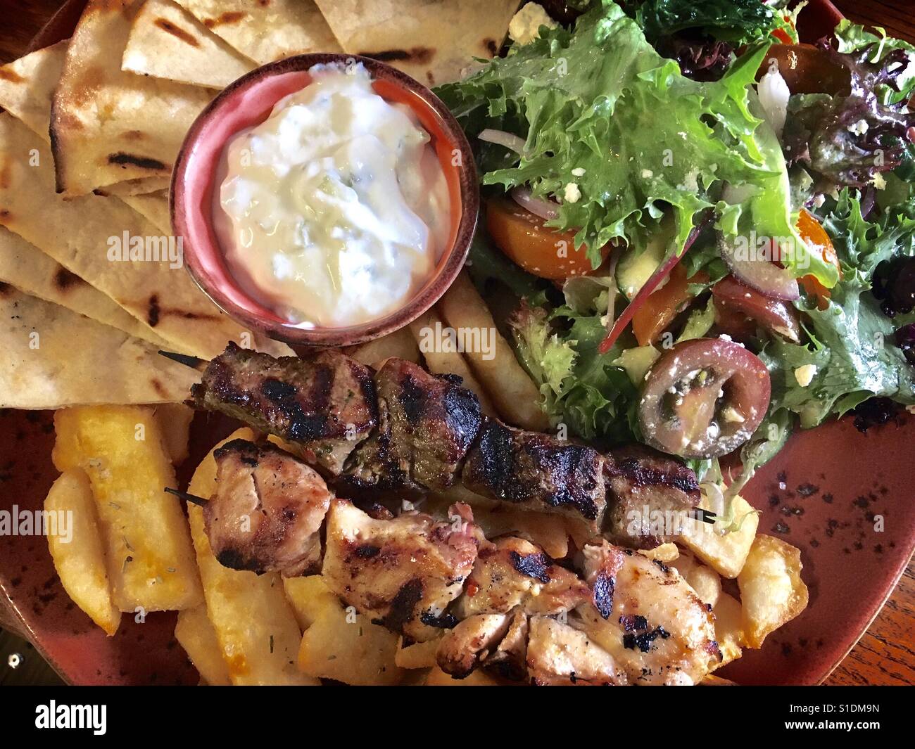 Souvlaki, peta, hot chips, sauce & salad' Stock Photo