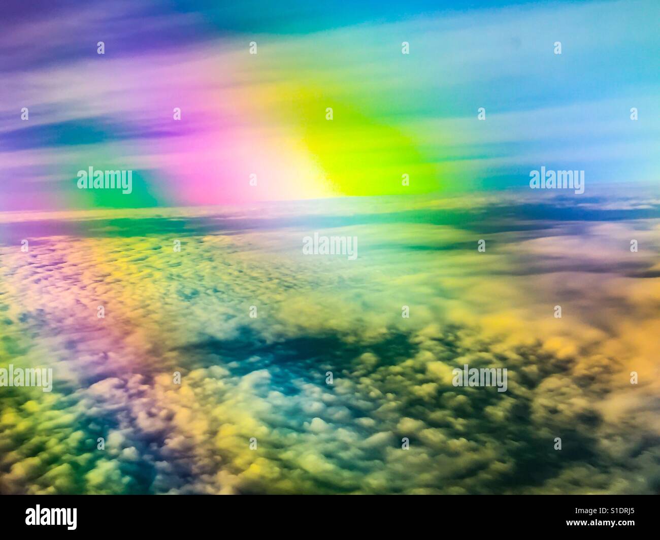 Clouds and sky in multicolour, photographed from inside a regular civilian flight. Aerial. Concepts: wonder, wonderment, rising above, refraction, joy Stock Photo