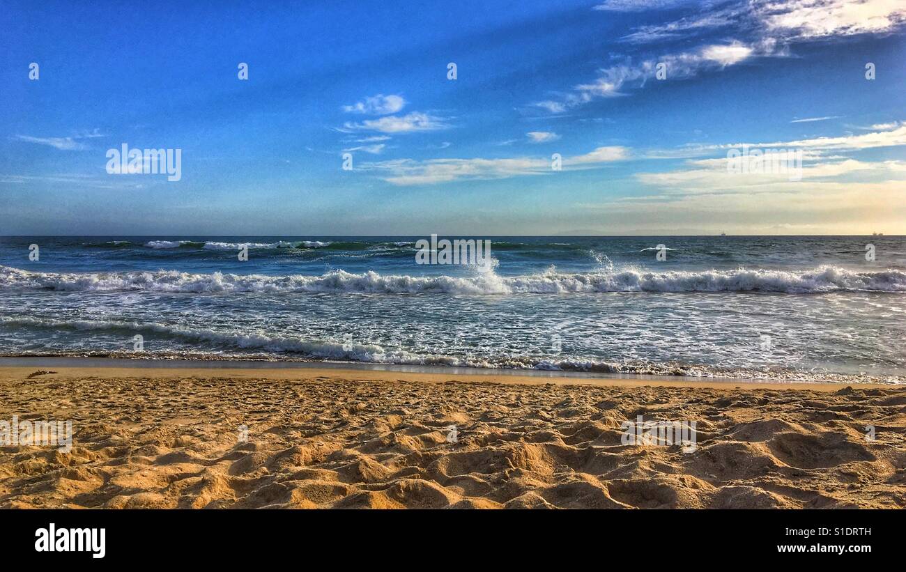 Sand, ocean and sky. Landscape view of the ocean and horizon from a sandy beach on a late afternoon sunny day. - Smartphone Captured Stock Image