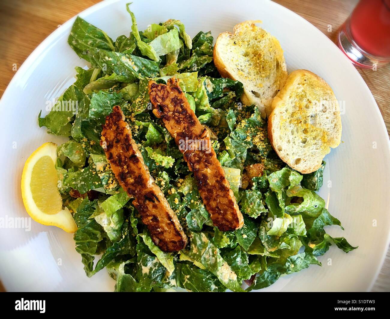 A Caesar salad with tempeh bacon Stock Photo Alamy