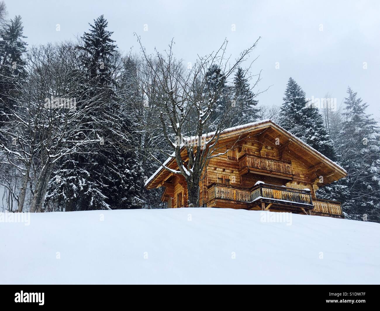 A Traditional Swiss Log Cabin In A Snowy Alpine Setting Stock