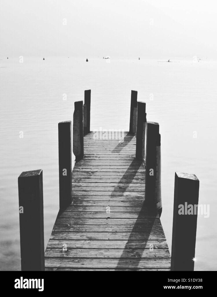 A wooden jetty or pier stretches out into the waters of Lake Annecy, France. Stock Photo