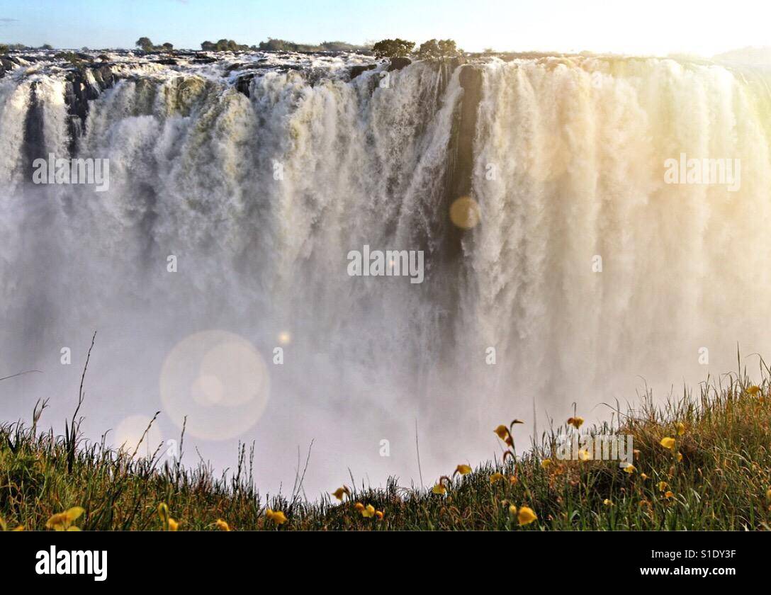 Water cascades over the mighty Victoria Falls at sunrise on the border of Zimbabwe and Zambia. Stock Photo