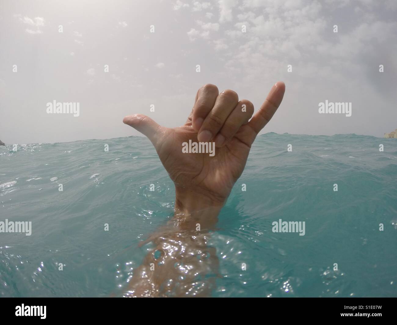 Hand in the water with Shaka sign Stock Photo