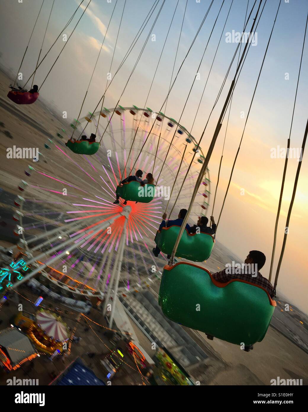 Tourists Enjoy A Ride In The Big Swing At A Fun Fair Or