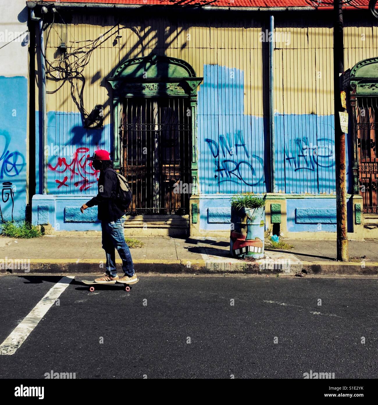 A Salvadoran young man rides a skateboard in front of a lower middle class house, with Spanish colonial architecture elements, built in the center of San Salvador, El Salvador, 14 November 2016. Stock Photo